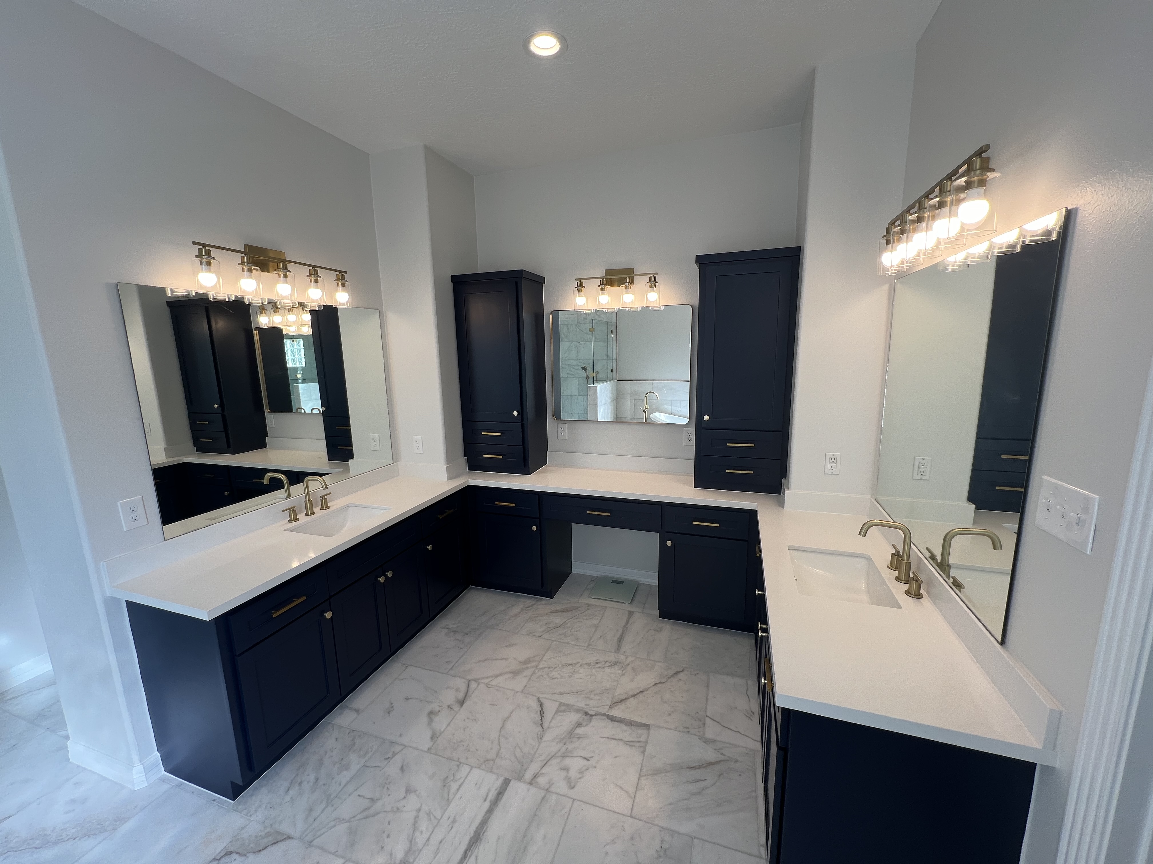 Navy vanity suite with dual sinks and gold fixtures
