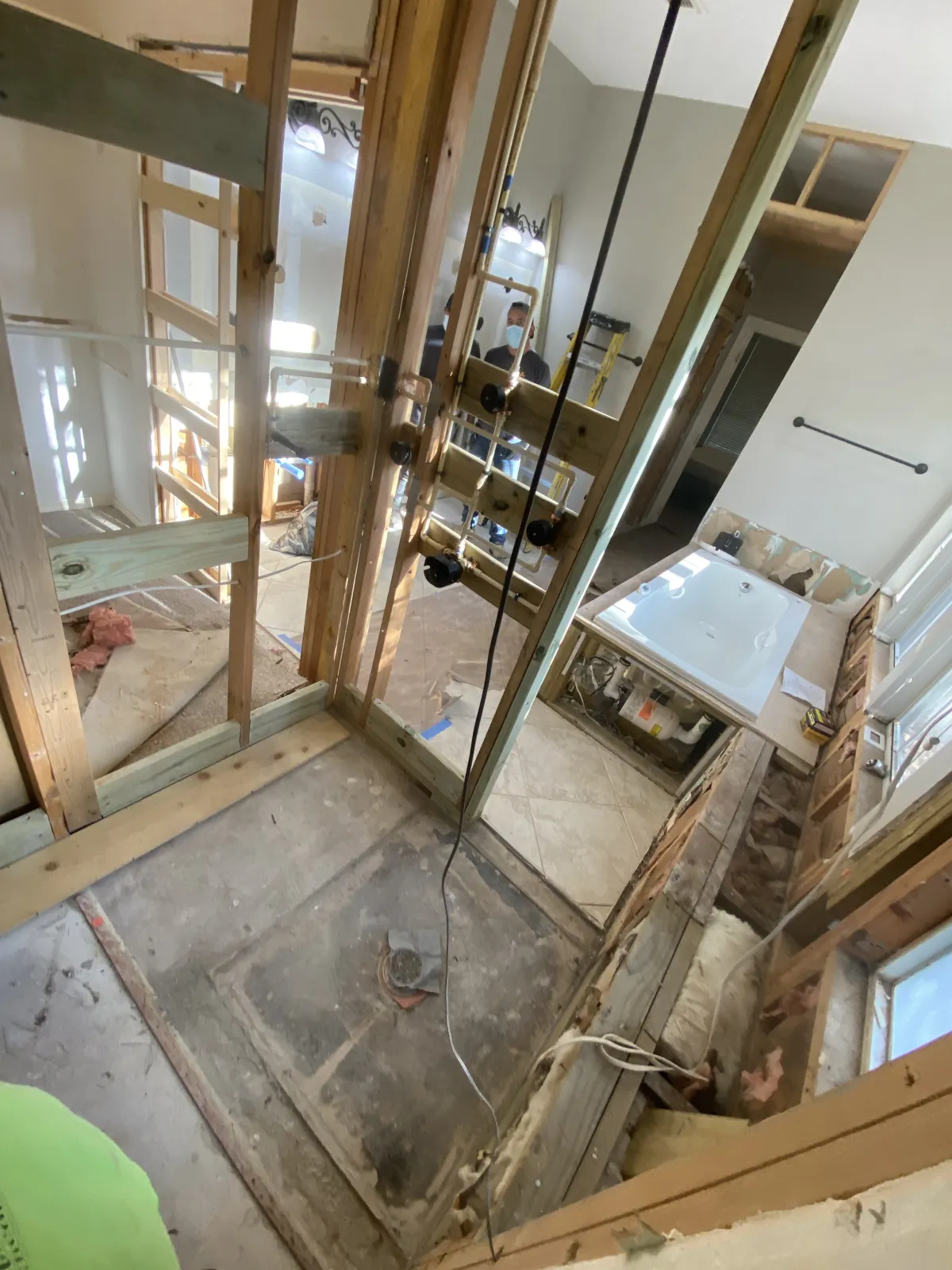 Bathroom gutted to exposed framing, plumbing rough-ins, and subfloor during demolition