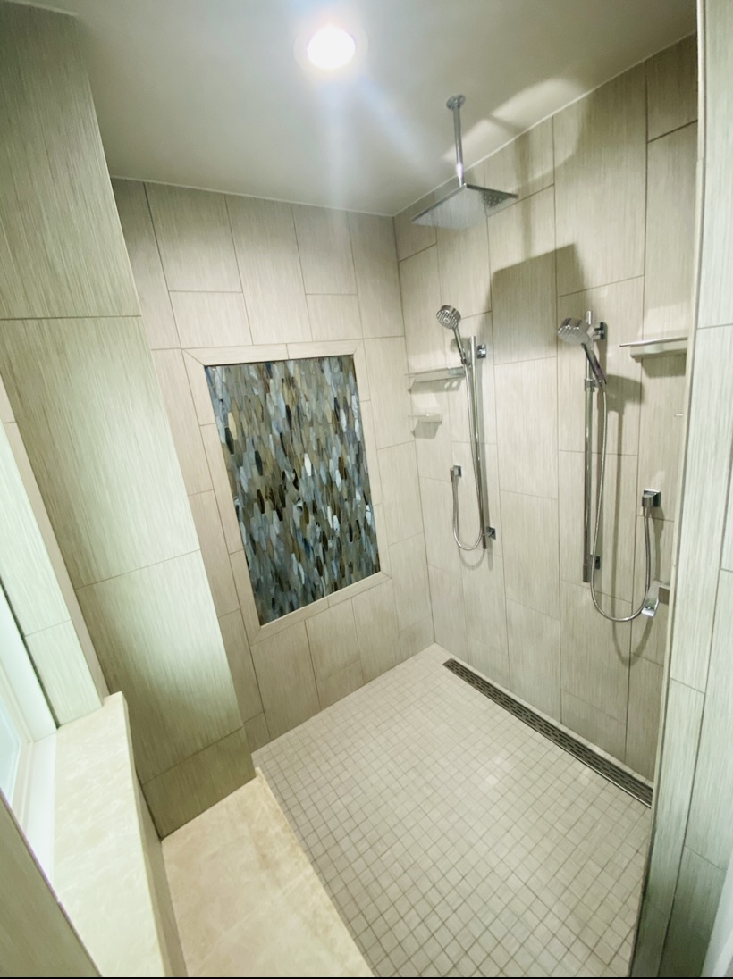 Walk-in shower with mosaic niche accent wall and rain showerhead