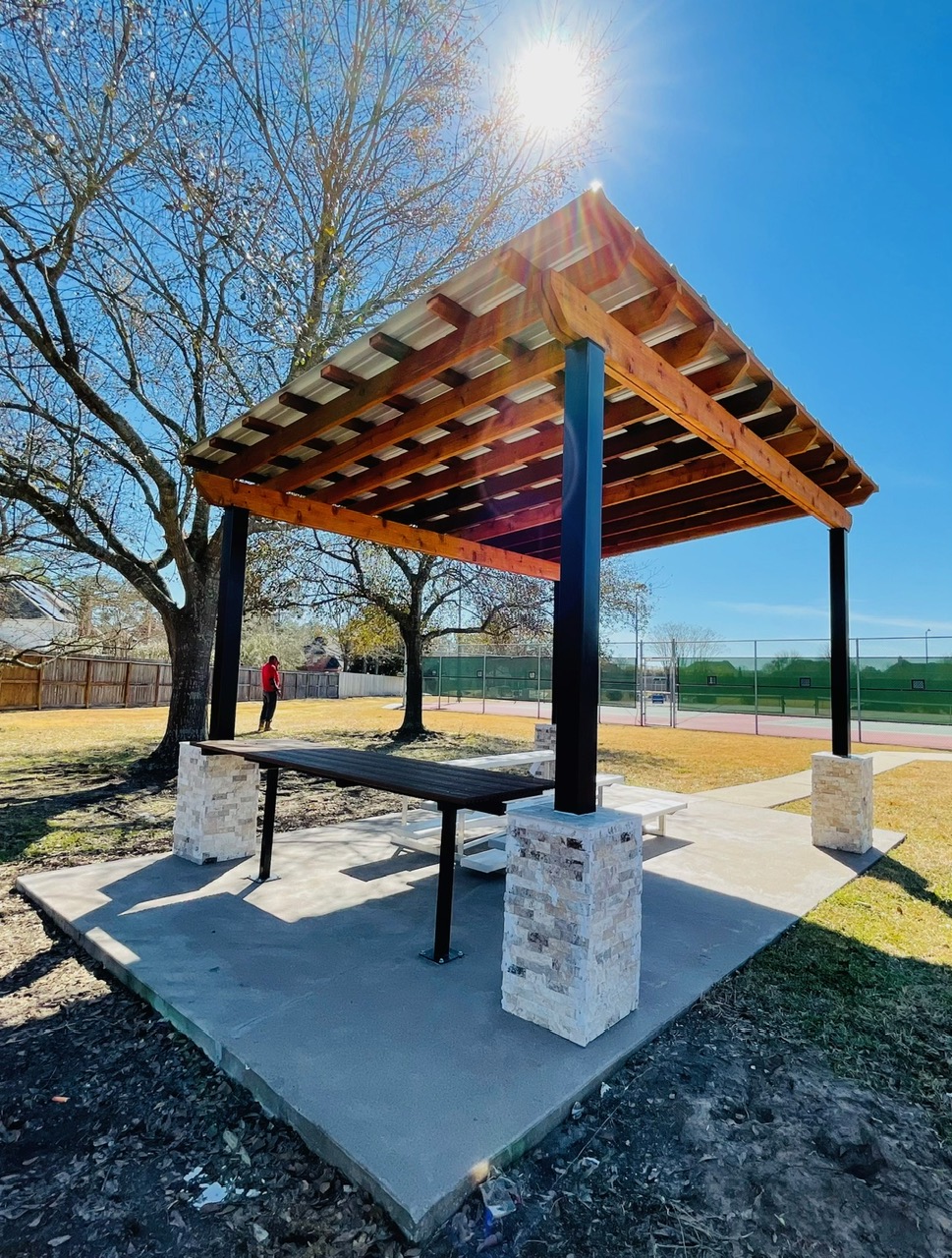 Custom outdoor pergola with cedar wood roof and stone columns