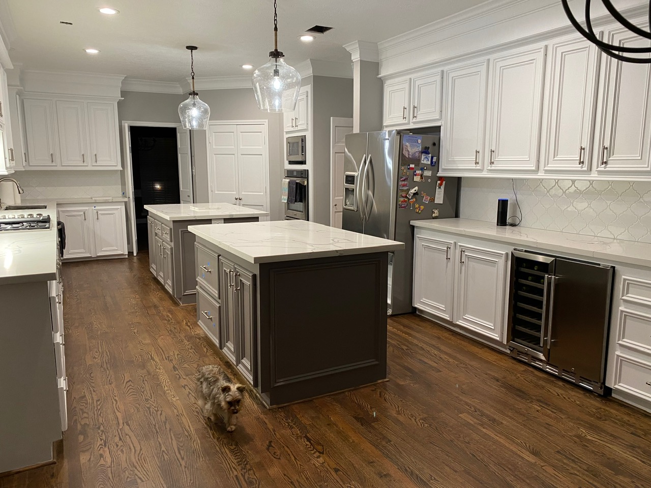 Open-concept kitchen with white cabinets, gray island, and wine cooler