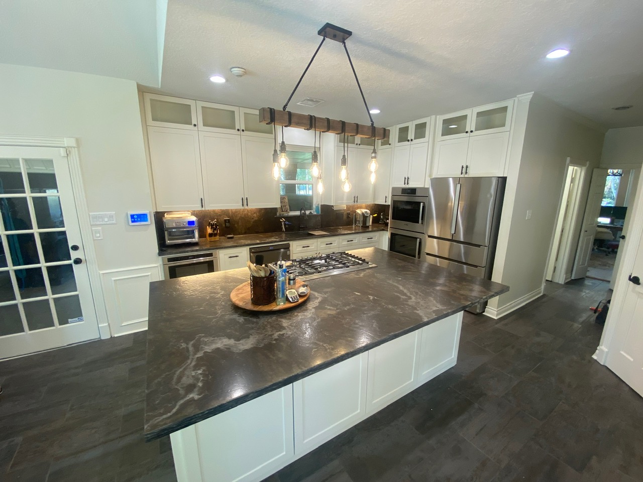 Kitchen with white shaker cabinets and rustic Edison-bulb chandelier