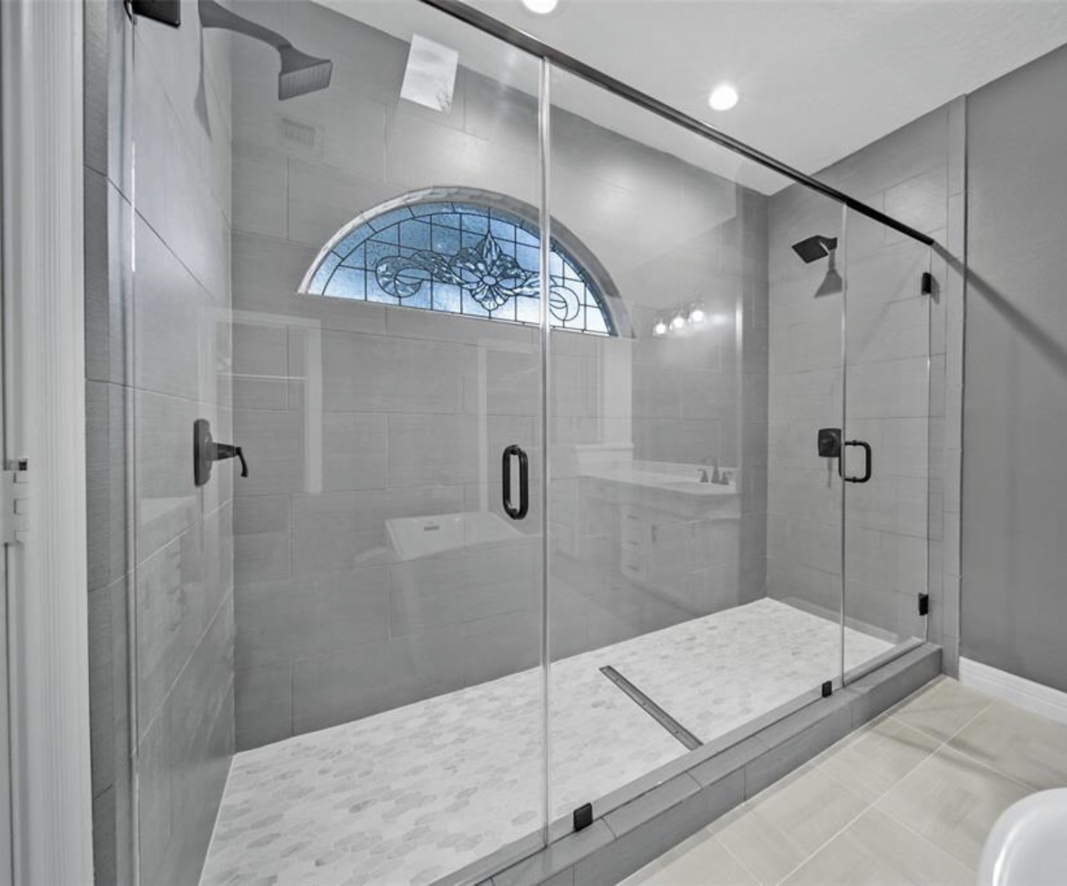 Frameless glass walk-in shower with stained glass window
