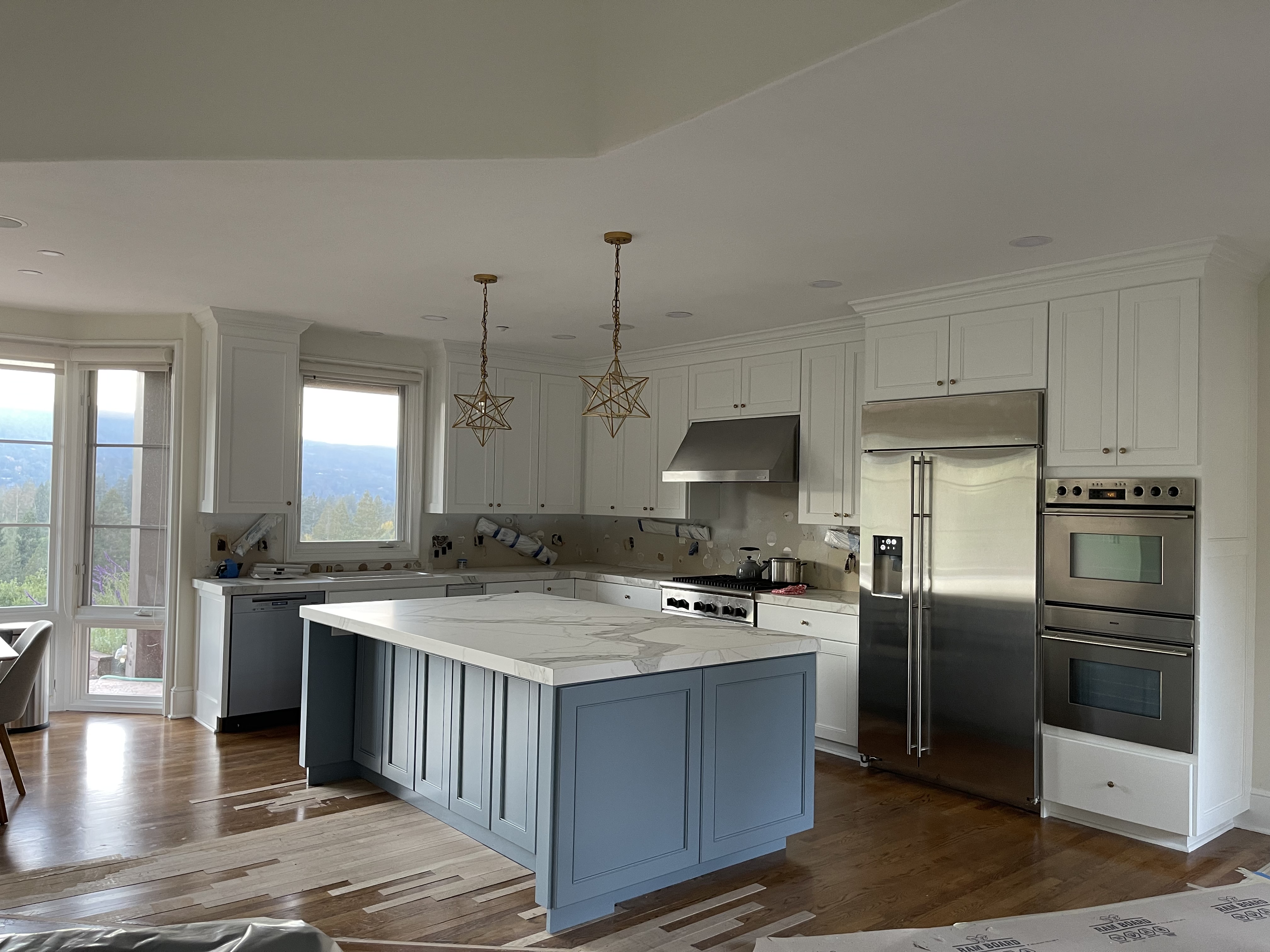 Modern kitchen remodel with blue island and gold pendants